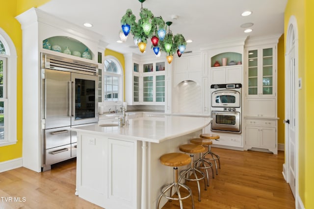133 Knob Creek Dock Rd, Johnson City, TN 37601 - kitchen featuring stainless steel appliances, light countertops, light wood finished floors, glass insert cabinets, and healthy amount of natural light