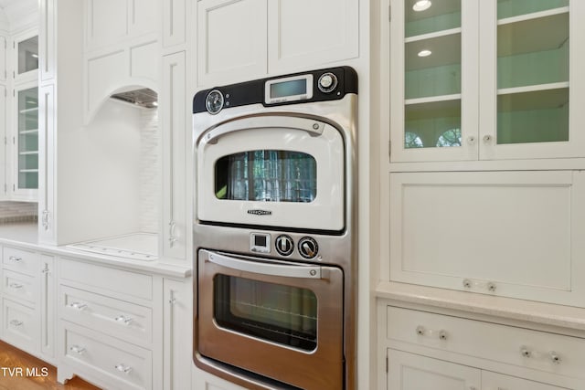 133 Knob Creek Dock Rd, Johnson City, TN 37601 - kitchen with estacked washer and dryer, light countertops, white cabinets, and glass insert cabinets