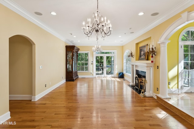 133 Knob Creek Dock Rd, Johnson City, TN 37601 - unfurnished living room featuring arched walkways, light wood-style flooring, a high end fireplace, crown molding, and a chandelier