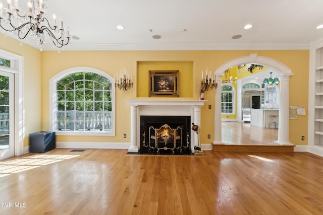 133 Knob Creek Dock Rd, Johnson City, TN 37601 - unfurnished living room with a chandelier, arched walkways, ornamental molding, a fireplace with flush hearth, and wood finished floors