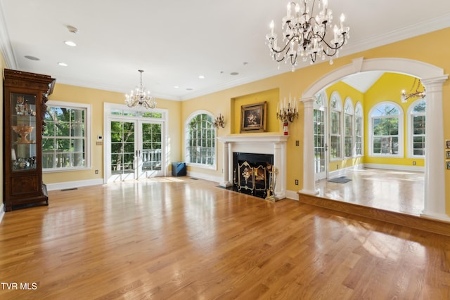 133 Knob Creek Dock Rd, Johnson City, TN 37601 - unfurnished living room featuring a chandelier, wood finished floors, a fireplace, arched walkways, and baseboards