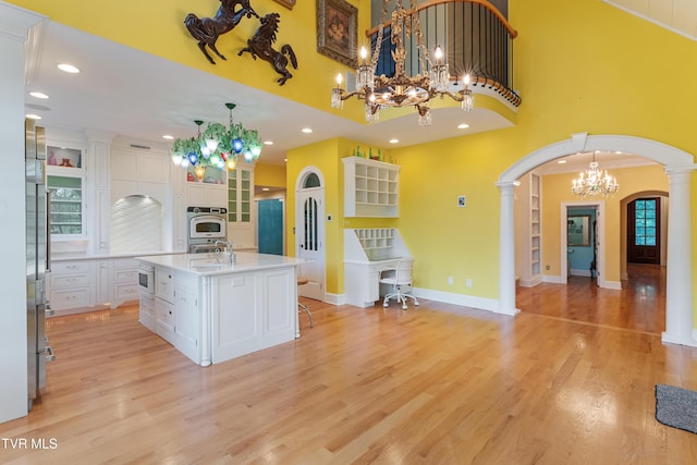 133 Knob Creek Dock Rd, Johnson City, TN 37601 - kitchen with stainless steel oven, arched walkways, a chandelier, white cabinetry, and a sink