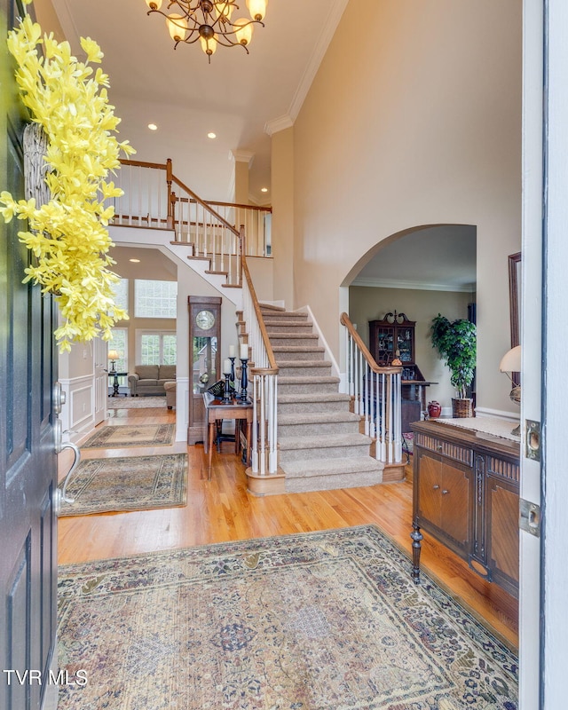 117 Quail Heights Ct, Kingsport, TN 37663 - entrance foyer featuring ornamental molding, stairway, wood finished floors, arched walkways, and a chandelier