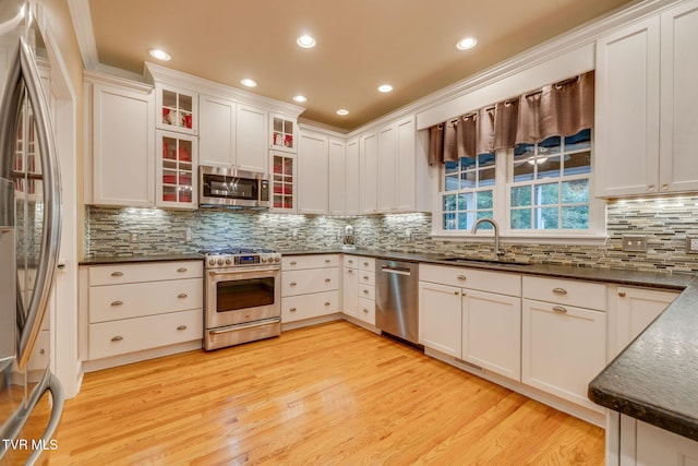 117 Quail Heights Ct, Kingsport, TN 37663 - kitchen featuring stainless steel appliances, a sink, light wood finished floors, decorative backsplash, and white cabinets