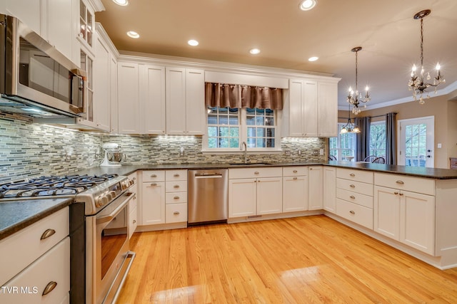 117 Quail Heights Ct, Kingsport, TN 37663 - kitchen featuring appliances with stainless steel finishes, a chandelier, a sink, light wood-style floors, and dark countertops