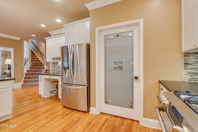 117 Quail Heights Ct, Kingsport, TN 37663 - kitchen with appliances with stainless steel finishes, dark countertops, backsplash, white cabinetry, and light wood-style floors