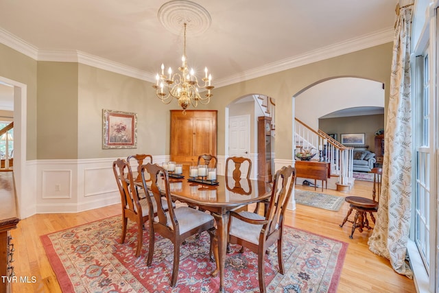 117 Quail Heights Ct, Kingsport, TN 37663 - dining space with arched walkways, light wood finished floors, ornamental molding, a chandelier, and a wainscoted wall
