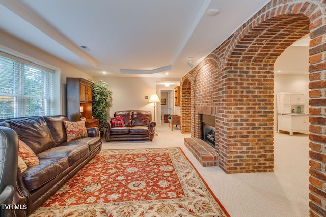 117 Quail Heights Ct, Kingsport, TN 37663 - living area with carpet flooring, a brick fireplace, a raised ceiling, arched walkways, and brick wall