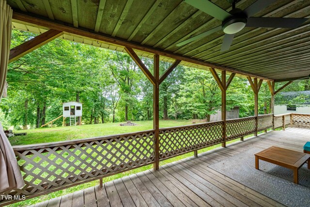 122 Spring Hollow Ln, Jonesborough, TN 37659 - deck featuring a playground, a yard, a ceiling fan, view of wooded area, and an outdoor fire pit