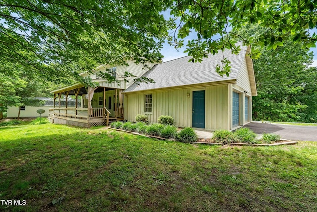 122 Spring Hollow Ln, Jonesborough, TN 37659 - view of front of house featuring board and batten siding, roof with shingles, asphalt driveway, a front lawn, and a wooden deck