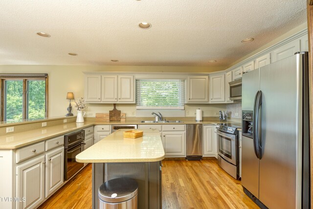 14346 White Top Vw, Abingdon, VA 24210 - kitchen featuring appliances with stainless steel finishes, a sink, a peninsula, light countertops, and a textured ceiling