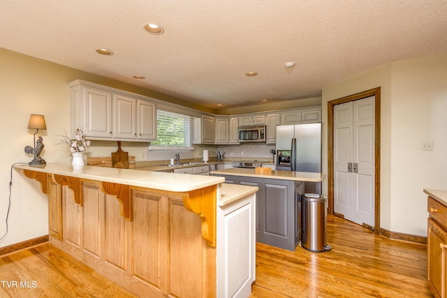 14346 White Top Vw, Abingdon, VA 24210 - kitchen with appliances with stainless steel finishes, a sink, a peninsula, light wood-type flooring, and baseboards