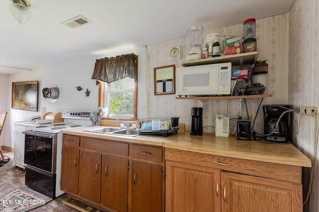 2170 Lone Mountain Rd, Tazewell, TN 37879 - kitchen featuring a sink, white appliances, light countertops, brown cabinetry, and wallpapered walls