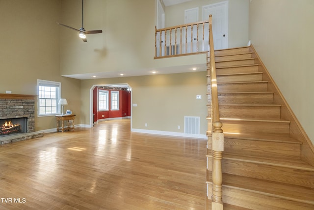 2361 Old Stage Rd, Afton, TN 37616 - stairway featuring a towering ceiling, a fireplace, wood finished floors, baseboards, and a ceiling fan