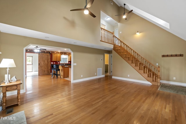 2361 Old Stage Rd, Afton, TN 37616 - unfurnished living room featuring ceiling fan, light wood-type flooring, stairway, baseboards, and high vaulted ceiling