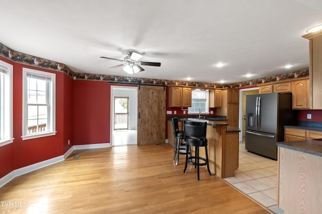 2361 Old Stage Rd, Afton, TN 37616 - kitchen with stainless steel fridge, a breakfast bar, dark countertops, and a ceiling fan