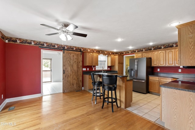 2361 Old Stage Rd, Afton, TN 37616 - kitchen featuring fridge with ice dispenser, a kitchen bar, dark countertops, a center island, and ceiling fan