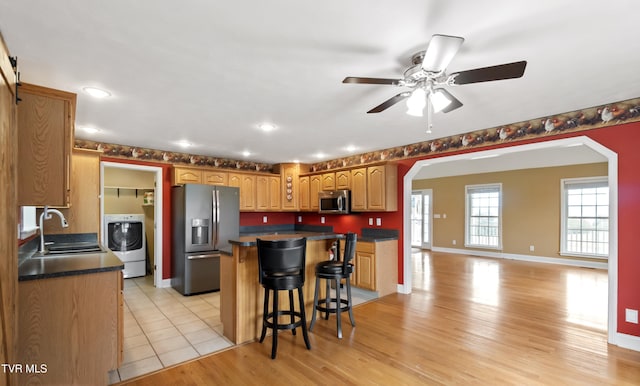 2361 Old Stage Rd, Afton, TN 37616 - kitchen with stainless steel appliances, arched walkways, washer / dryer, a sink, and dark countertops