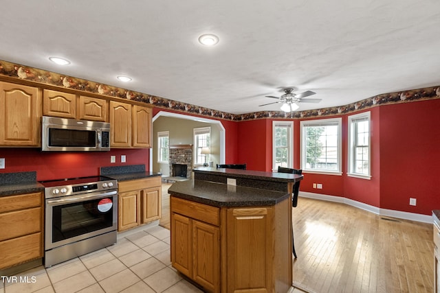 2361 Old Stage Rd, Afton, TN 37616 - kitchen featuring stainless steel appliances, a ceiling fan, dark countertops, baseboards, and a kitchen island