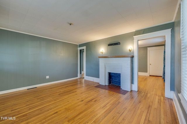 905 Kentucky Ave, Bristol, TN 37620 - unfurnished living room featuring hardwood / wood-style flooring, ornamental molding, and a brick fireplace