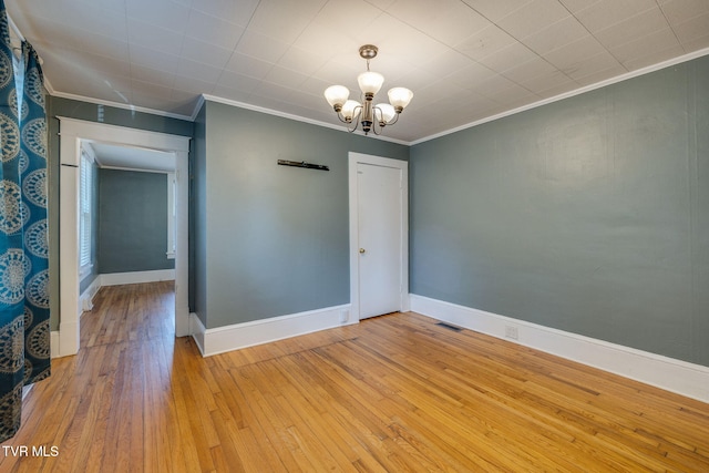 905 Kentucky Ave, Bristol, TN 37620 - empty room with crown molding, light wood-style flooring, and a chandelier