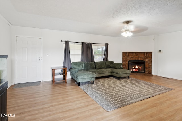 364 Berry Ridge Rd, Jonesborough, TN 37659 - living area featuring a warm lit fireplace, a ceiling fan, wood finished floors, a textured ceiling, and baseboards