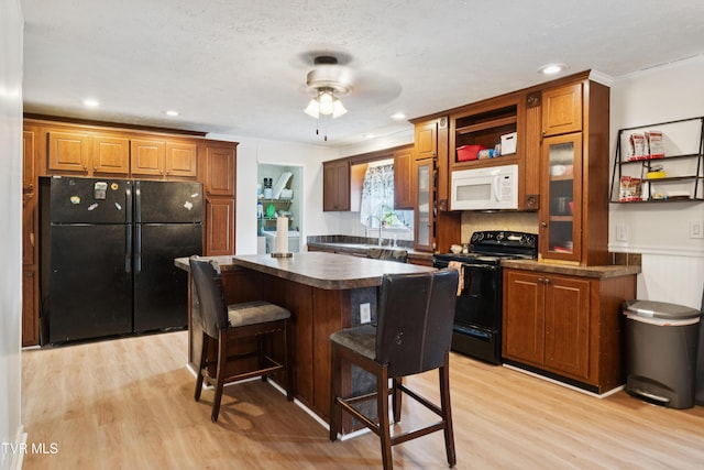 364 Berry Ridge Rd, Jonesborough, TN 37659 - kitchen with black appliances, dark countertops, light wood-type flooring, brown cabinets, and recessed lighting