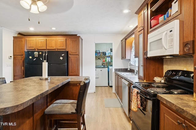 364 Berry Ridge Rd, Jonesborough, TN 37659 - kitchen featuring black appliances, dark countertops, a sink, light wood finished floors, and a kitchen breakfast bar