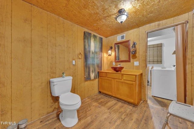 1275 Chuckey Pike, Chuckey, TN 37641 - bathroom featuring separate washer and dryer, toilet, wood finished floors, vanity, and wood walls
