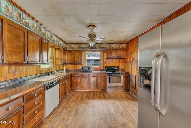 1275 Chuckey Pike, Chuckey, TN 37641 - kitchen with stainless steel appliances, a sink, dark countertops, light wood finished floors, and wooden walls