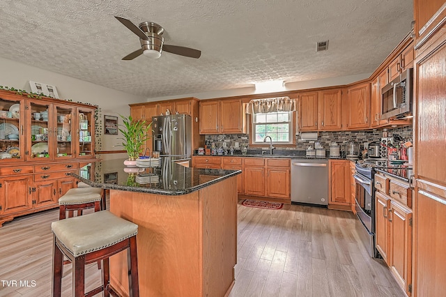 205 Live Oak Dr, Kingsport, TN 37660 - kitchen with stainless steel appliances, a textured ceiling, a ceiling fan, a sink, and light wood-type flooring