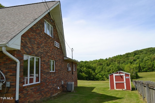 290 Kinchloe Mill Rd, Jonesborough, TN 37659 - view of property exterior featuring cooling unit, brick siding, roof with shingles, and a forest view