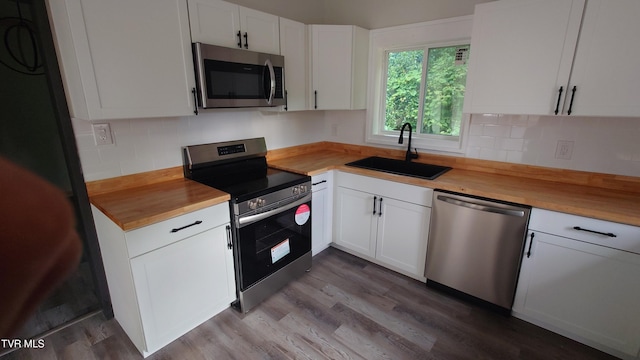 616 6th St, Bristol, TN 37620 - kitchen with stainless steel appliances, a sink, butcher block counters, white cabinetry, and backsplash