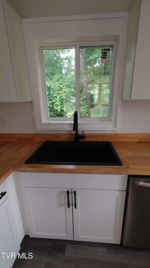 616 6th St, Bristol, TN 37620 - kitchen featuring butcher block countertops, a sink, stainless steel dishwasher, decorative backsplash, and white cabinetry