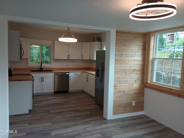 616 6th St, Bristol, TN 37620 - kitchen with appliances with stainless steel finishes, a sink, dark wood finished floors, healthy amount of natural light, and wood walls