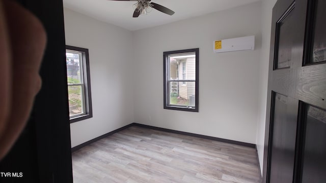 616 6th St, Bristol, TN 37620 - spare room featuring a wall mounted AC, plenty of natural light, light wood finished floors, and a ceiling fan