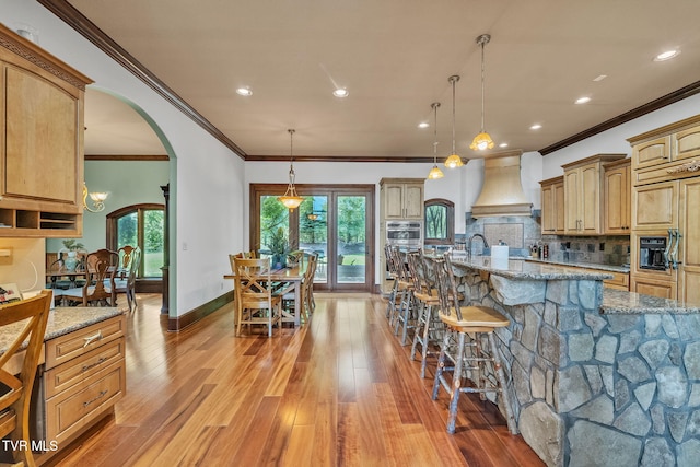 18549 Landridge Way, Abingdon, VA 24211 - kitchen with custom range hood, crown molding, light stone counters, a breakfast bar area, and decorative backsplash