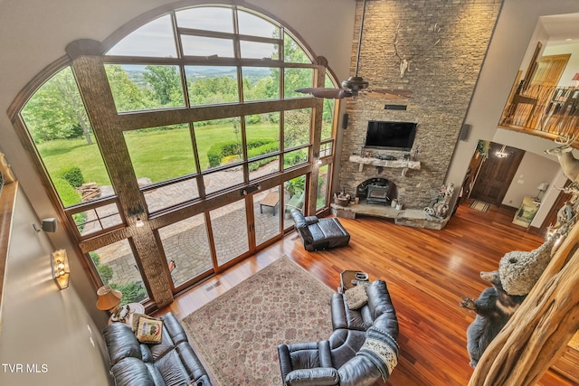 18549 Landridge Way, Abingdon, VA 24211 - living room featuring a towering ceiling, a ceiling fan, a fireplace, and wood finished floors