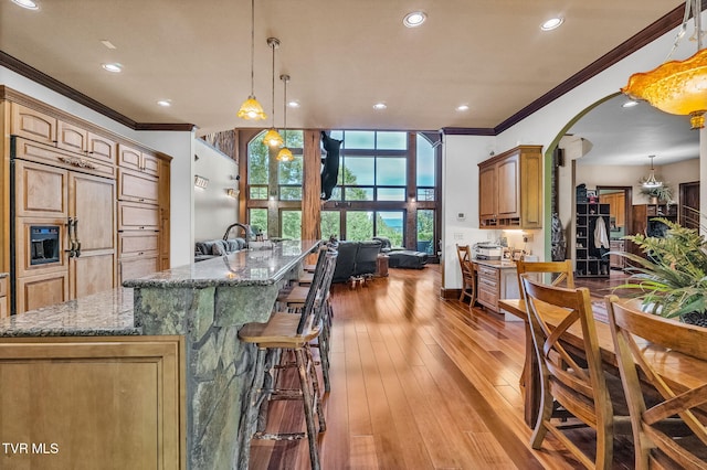18549 Landridge Way, Abingdon, VA 24211 - kitchen featuring ornamental molding, a breakfast bar area, a spacious island, dark stone counters, and arched walkways