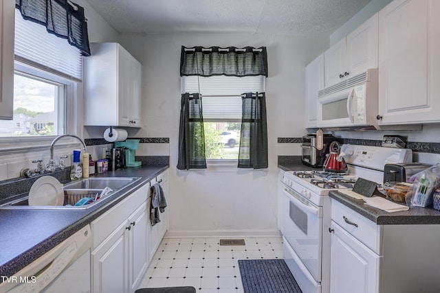 1321 Pineola Ave, Kingsport, TN 37664 - kitchen with white appliances, a sink, plenty of natural light, dark countertops, and a textured ceiling
