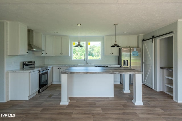 385 Piney Grove Rd, Greeneville, TN 37743 - kitchen with wall chimney exhaust hood, stainless steel appliances, a barn door, decorative backsplash, and a textured ceiling