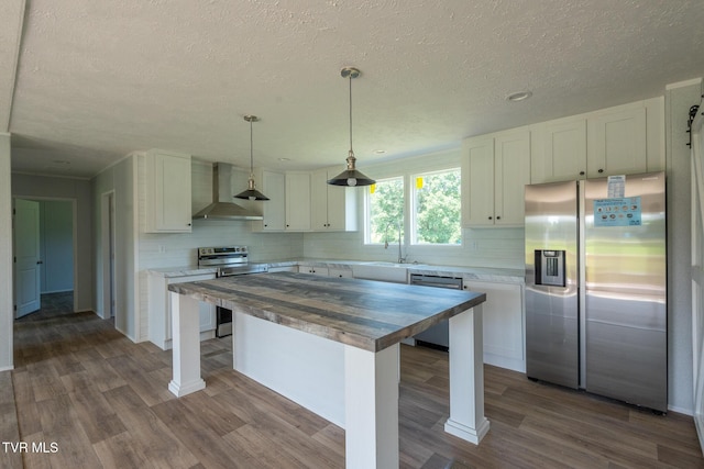 385 Piney Grove Rd, Greeneville, TN 37743 - kitchen with appliances with stainless steel finishes, wall chimney exhaust hood, wooden counters, a sink, and tasteful backsplash