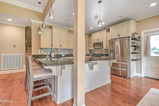 133 Christopher Way, Blountville, TN 37617 - kitchen with stainless steel appliances, crown molding, cream cabinets, dark stone counters, and a kitchen breakfast bar