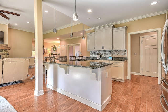 133 Christopher Way, Blountville, TN 37617 - kitchen with a breakfast bar, ornamental molding, open floor plan, ceiling fan, and dark stone counters