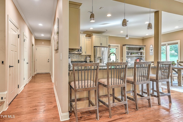133 Christopher Way, Blountville, TN 37617 - kitchen with stainless steel fridge with ice dispenser, ornamental molding, light wood-style flooring, a kitchen bar, and cream cabinetry