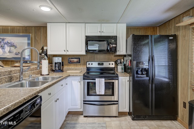 111 Jd Whitehead Rd, Roan Mountain, TN 37687 - kitchen with black appliances, wooden walls, white cabinetry, and light countertops