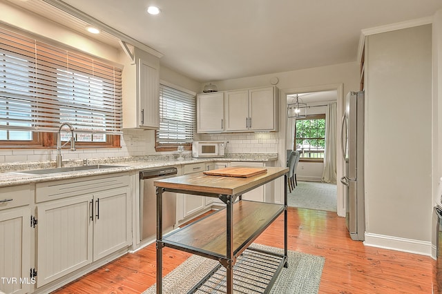 1449 Warpath Dr, Kingsport, TN 37664 - kitchen with stainless steel appliances, a sink, decorative backsplash, light countertops, and white cabinetry