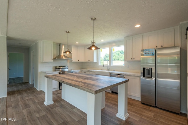 255 Piney Grove Rd, Greeneville, TN 37743 - kitchen with butcher block countertops, wall chimney exhaust hood, appliances with stainless steel finishes, a sink, and a textured ceiling
