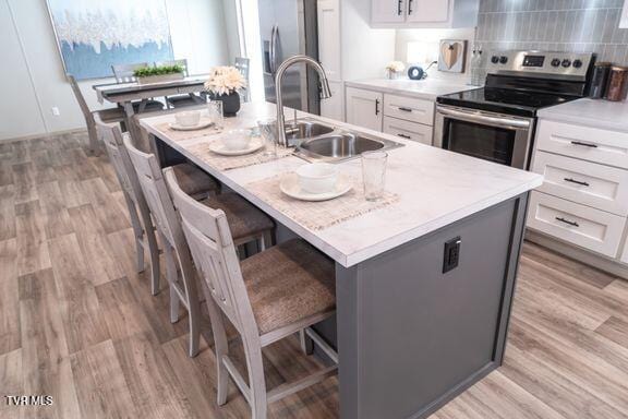 913 Henry Harr Rd, Blountville, TN 37617 - kitchen with stainless steel appliances, white cabinets, light countertops, and an island with sink