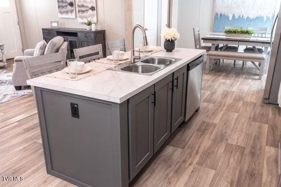 913 Henry Harr Rd, Blountville, TN 37617 - kitchen with stainless steel dishwasher, gray cabinets, an island with sink, a sink, and light wood-style flooring